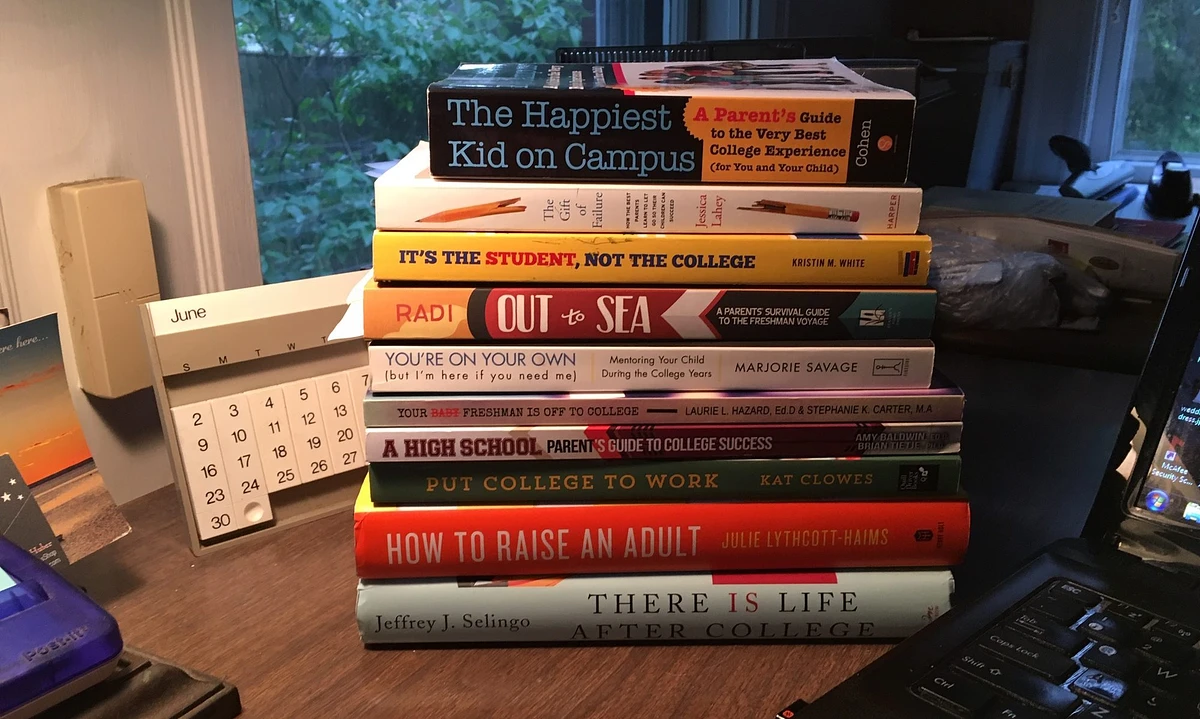 A stack of books sits on a desk