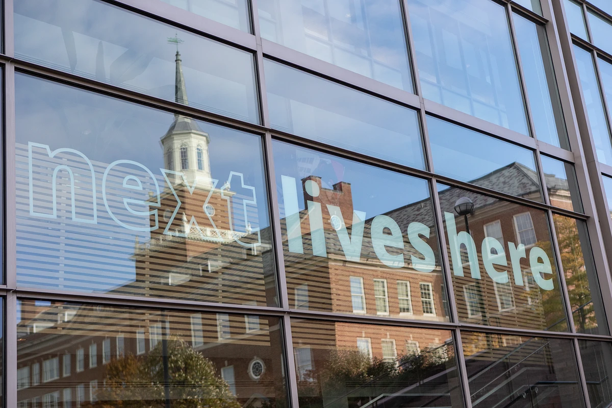 Image of UC Building with Text on window "Next Lives Here"