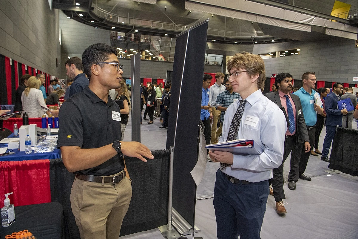A student speaks with a potential employer at a UC Career Fair