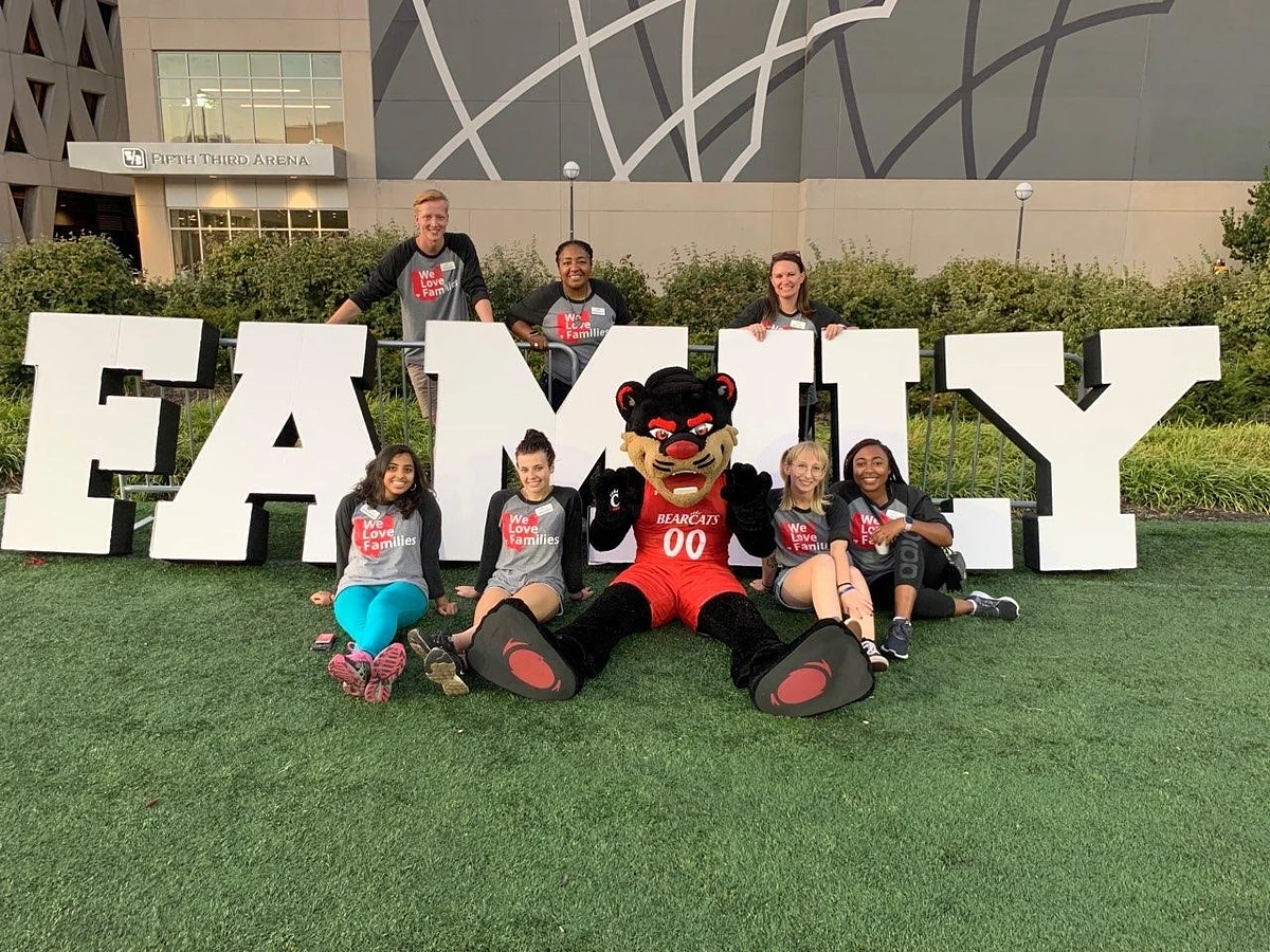 Students and staff pose with the Bearcat by large letters reading "FAMILY"