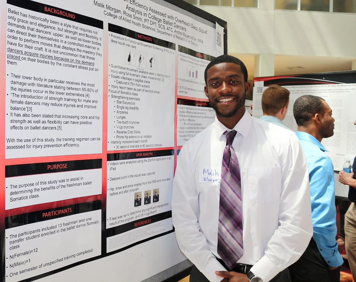 Student Malik Morgan poses at a research poster session