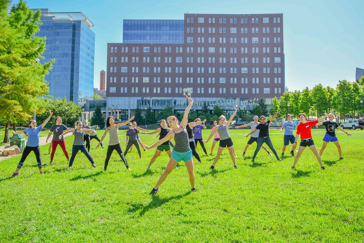 Students doing yoga on a sunny day on the campus green